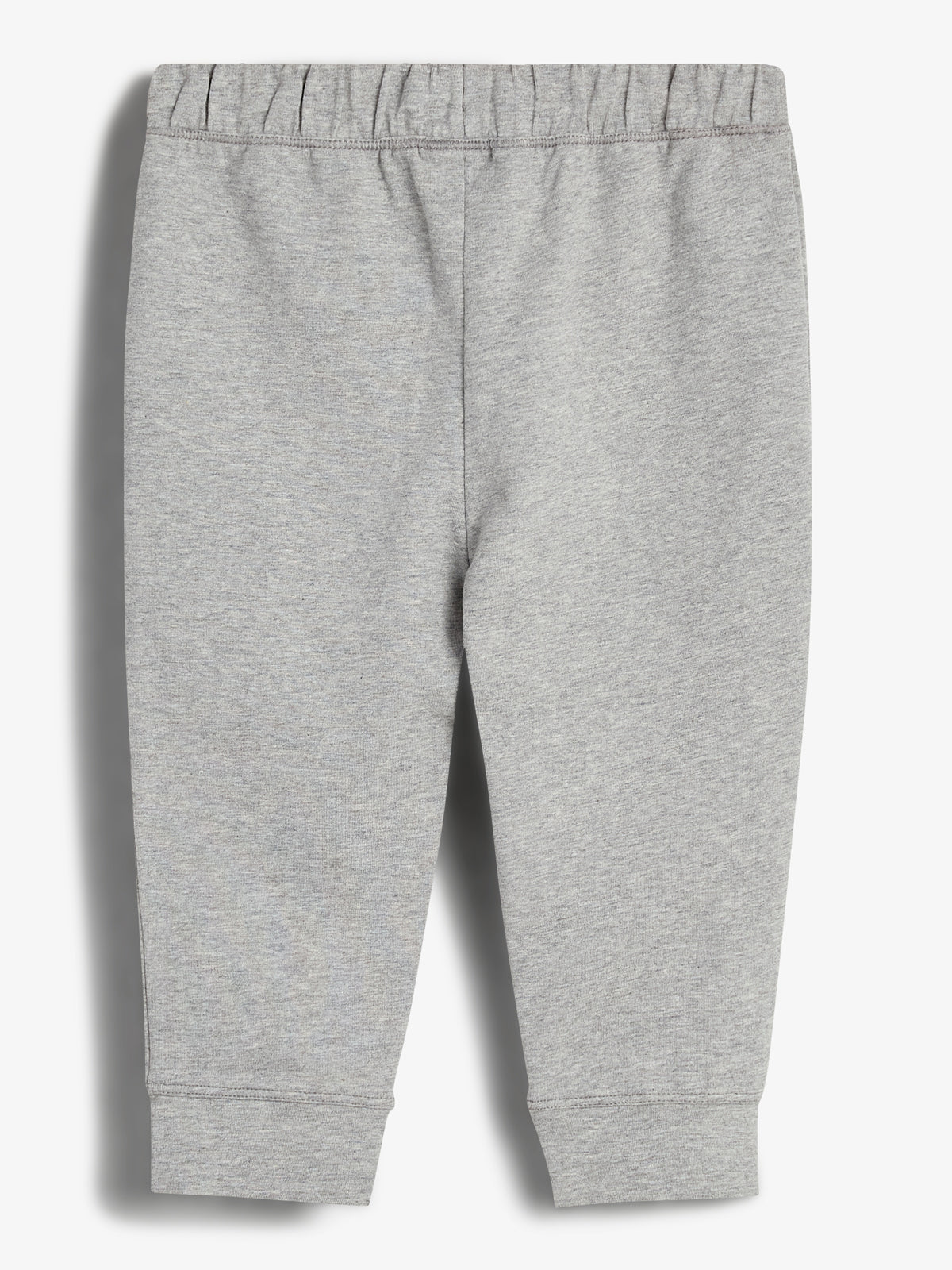 Grå joggingbukser, hænger i afslappet stil, vist mod hvid baggrund. Elastisk talje og ribkanter giver komfortabel pasform. Buksernes enkle design gør dem alsidige til daglig brug.
