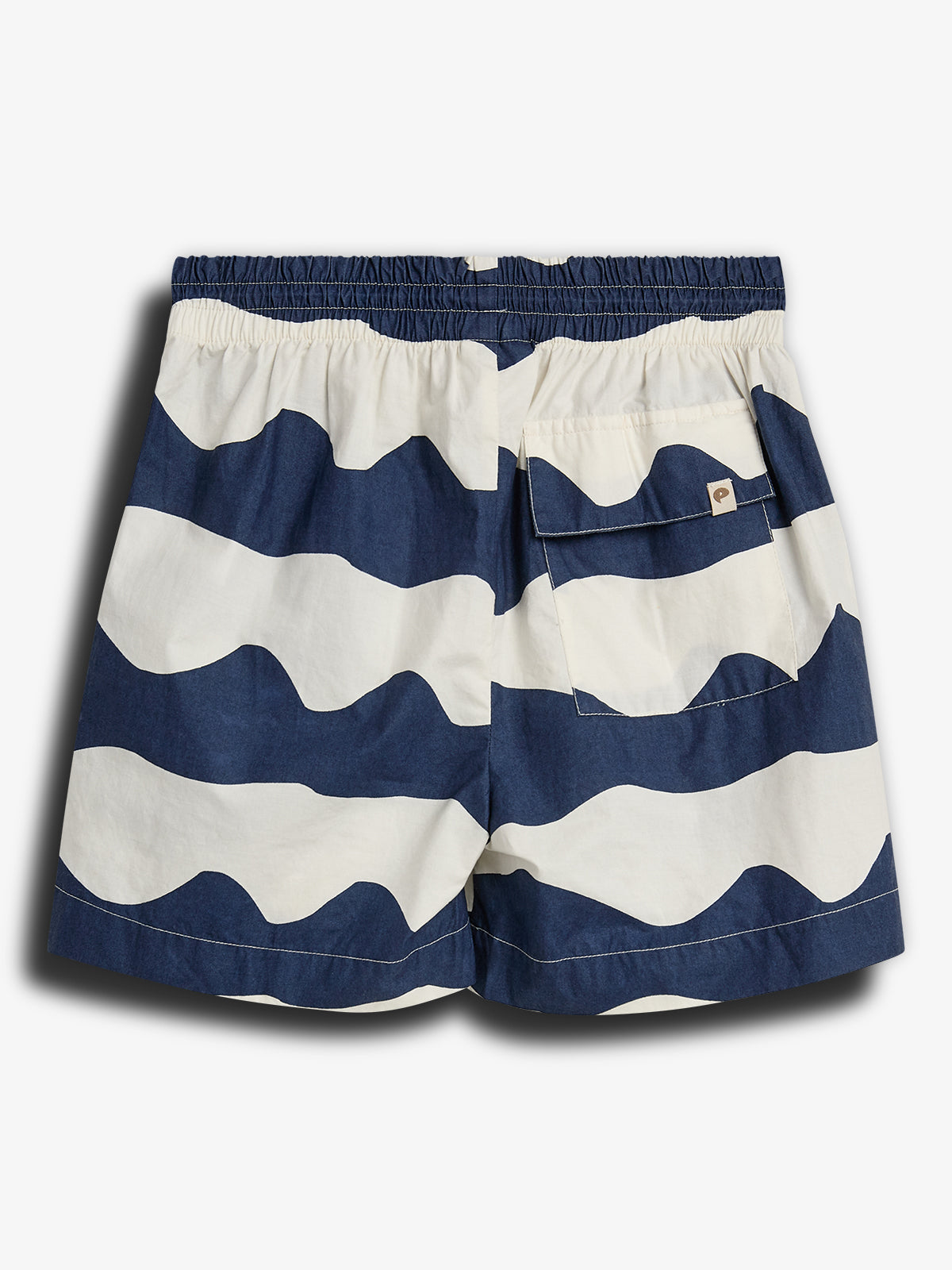 Shorts med blå og hvide bølgemønstre, ligger fladt med elastik i taljen, en lomme med flap er bagpå. De er sat mod en simpel, hvid baggrund.