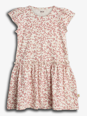 Kjolen har et hvidt stof med rødt blomsterprint, korte ærmer og en rynket nederdel. Den hænger mod en neutral baggrund. Mærket indeni siger: "POMPdeLUX, Made with care."