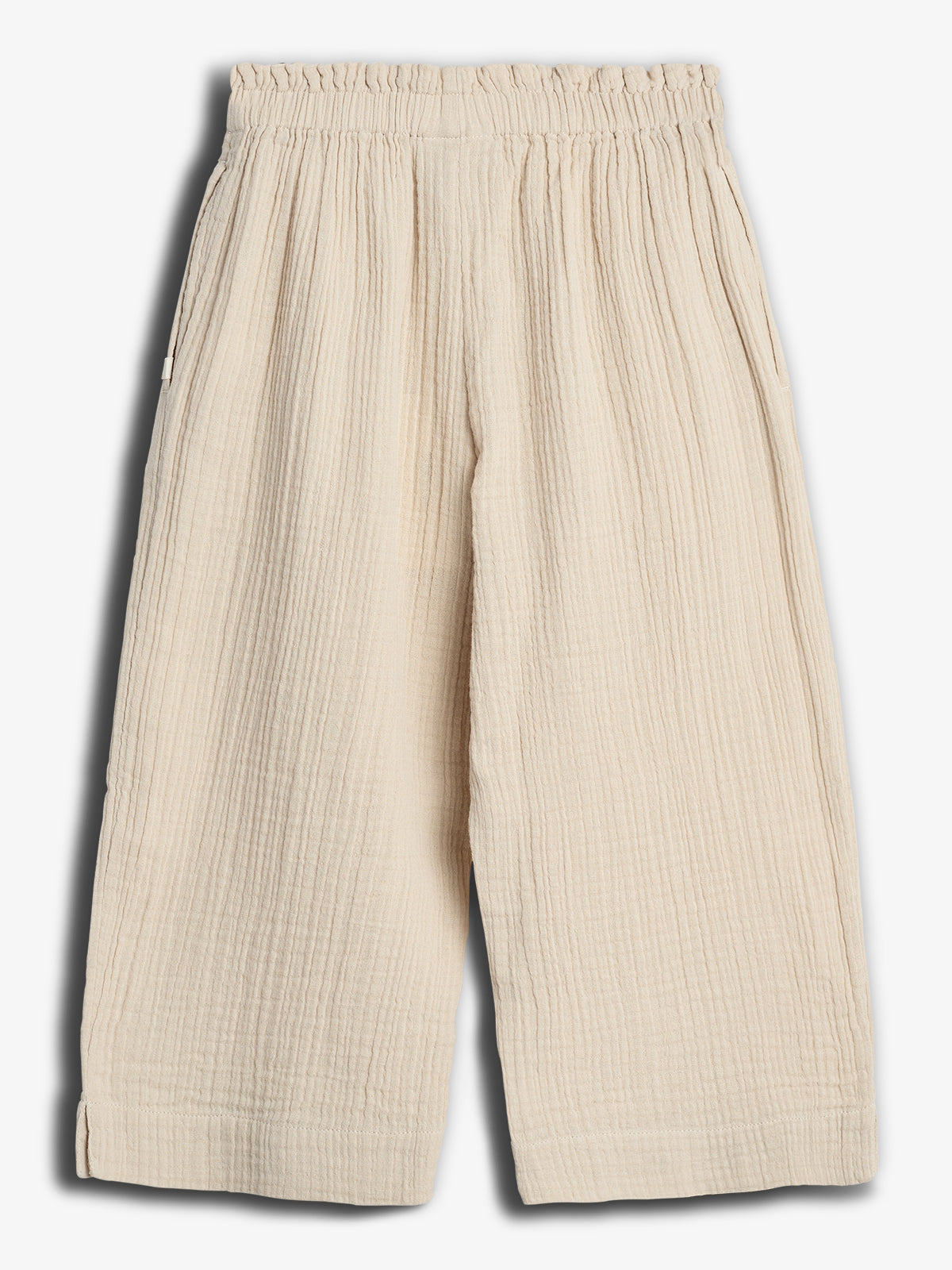 Beige, wide-leg pants with an elastic waistband displayed against a plain white background. The fabric has a textured, crinkled appearance, featuring visible seams and two side pockets.