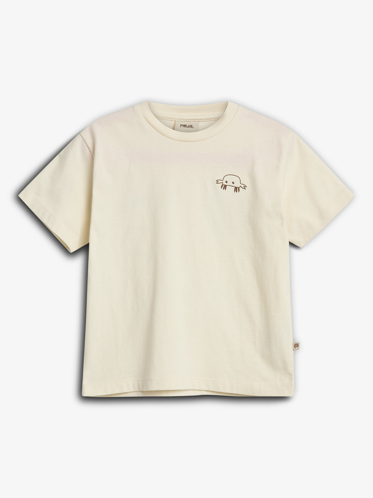 A cream-colored T-shirt features a small, simple drawing of an axolotl on the left chest, set against a plain white background.