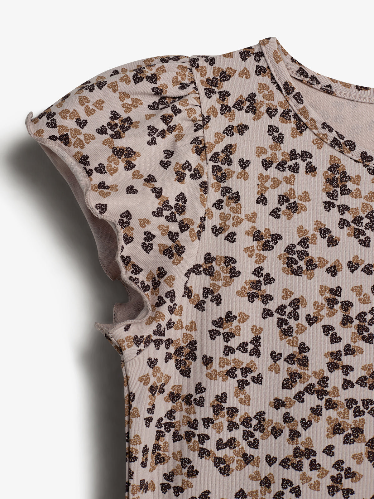 T-shirt med krøllede ærmer er mønstret med små sorte og brune blomster. Designet er præsenteret på en hvid baggrund uden tekst eller yderligere elementer.