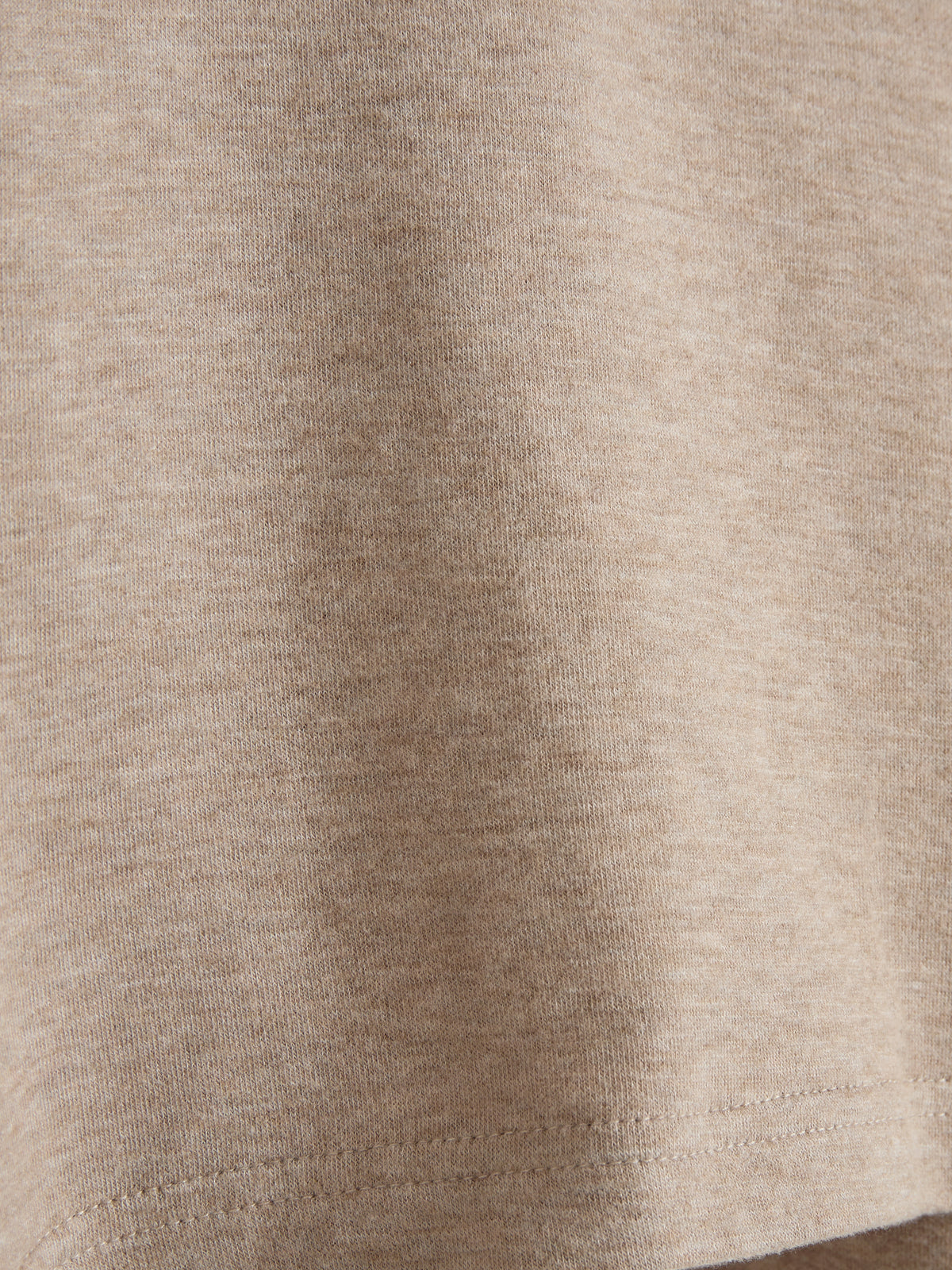 Beige stof med synlige tråde falder roligt. Stoffet har en jævn tekstur. Der er ingen tekst til stede.