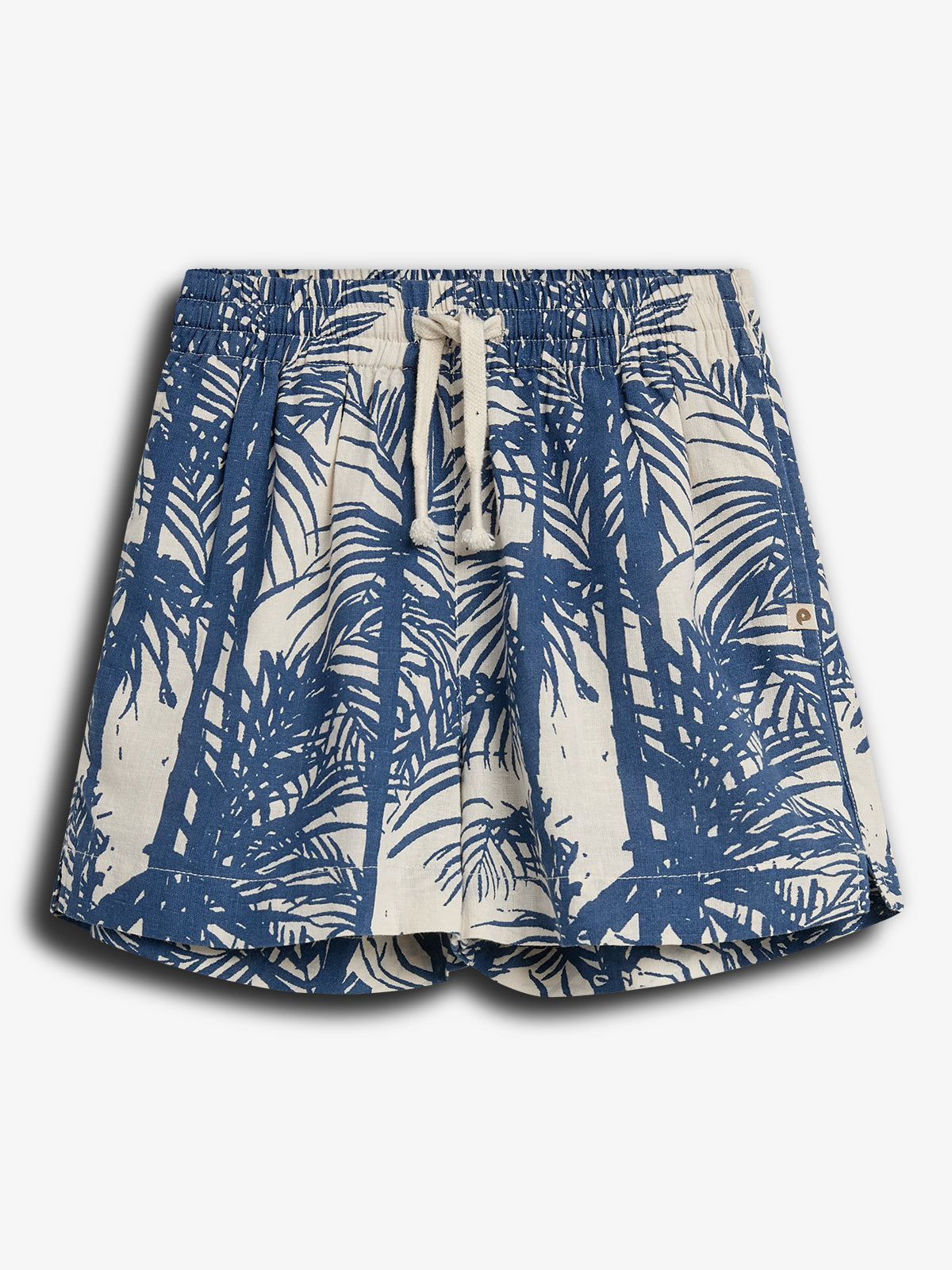 Shorts med bladmønster i mørkeblå på beige baggrund. Elastisk talje med hvid snor. Baggrund er hvid, hvilket fremhæver shortsens tropiske design.