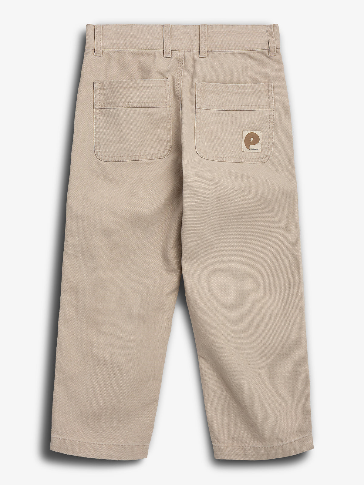 Bukser set bagfra, med to baglommer og et lille mærke på højre lomme. Bukserne er beige og hænger i et neutralt, lys miljø.