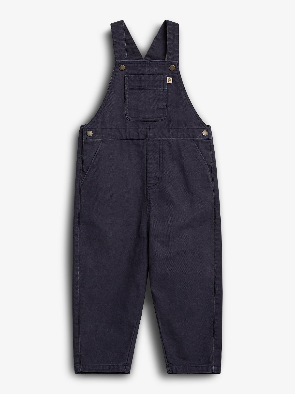 Mørkeblå overall i denim-stil, ligger fladt på en hvid baggrund. Designet har et brystlomme og justerbare skulderstropper med metalspænder, velegnet til afslappet brug.