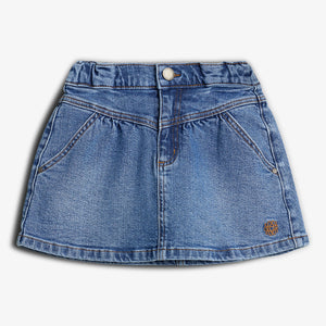 Jeansnederdel; ligger fladt med lommer og knap foran; lys denimstof; mod hvid baggrund.
