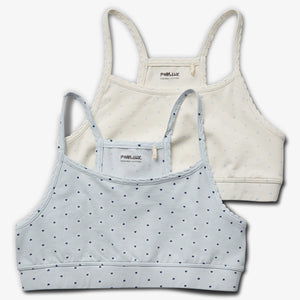 To toppe med stropper ligger ovenpå hinanden; én lyseblå med små hjerter foran, én cremefarvet bagved. Tekst: "POMPdeLUX ORGANIC COTTON" på begge i etiketten.