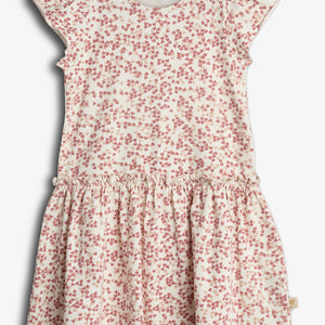 Kjolen har et hvidt stof med rødt blomsterprint, korte ærmer og en rynket nederdel. Den hænger mod en neutral baggrund. Mærket indeni siger: "POMPdeLUX, Made with care."