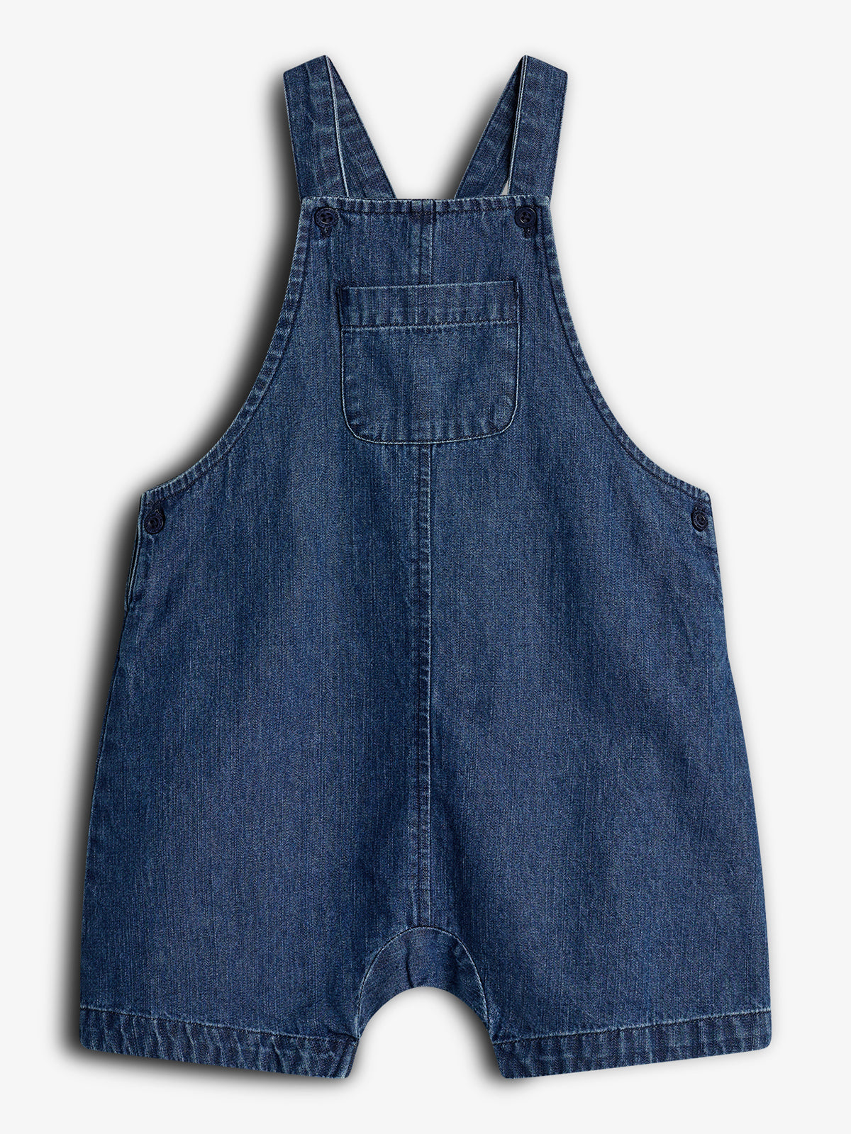 Blå denim smækbukser hænger, med justerbare stropper og en frontlomme, mod en hvid baggrund. Bukserne er simple i designet, velegnet til børn.