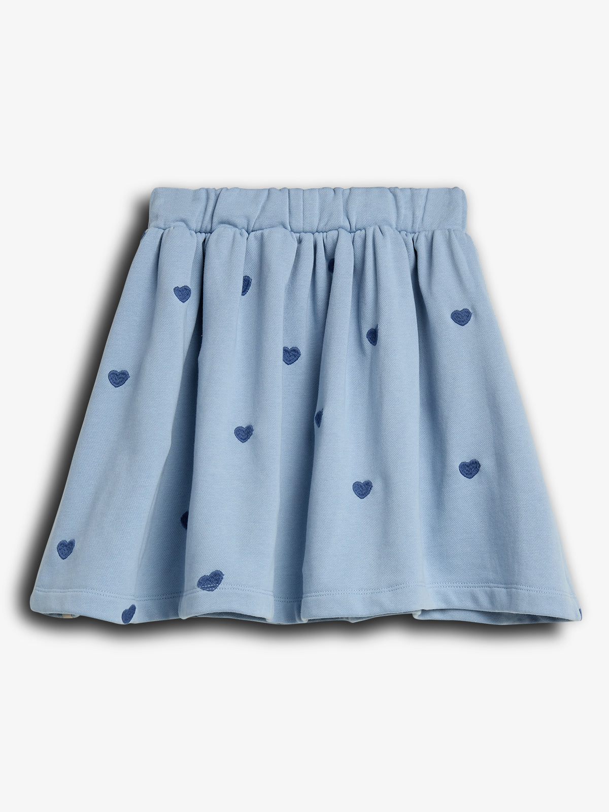 A light blue skirt with an elastic waistband, decorated with dark blue heart patterns, set against a plain white background.