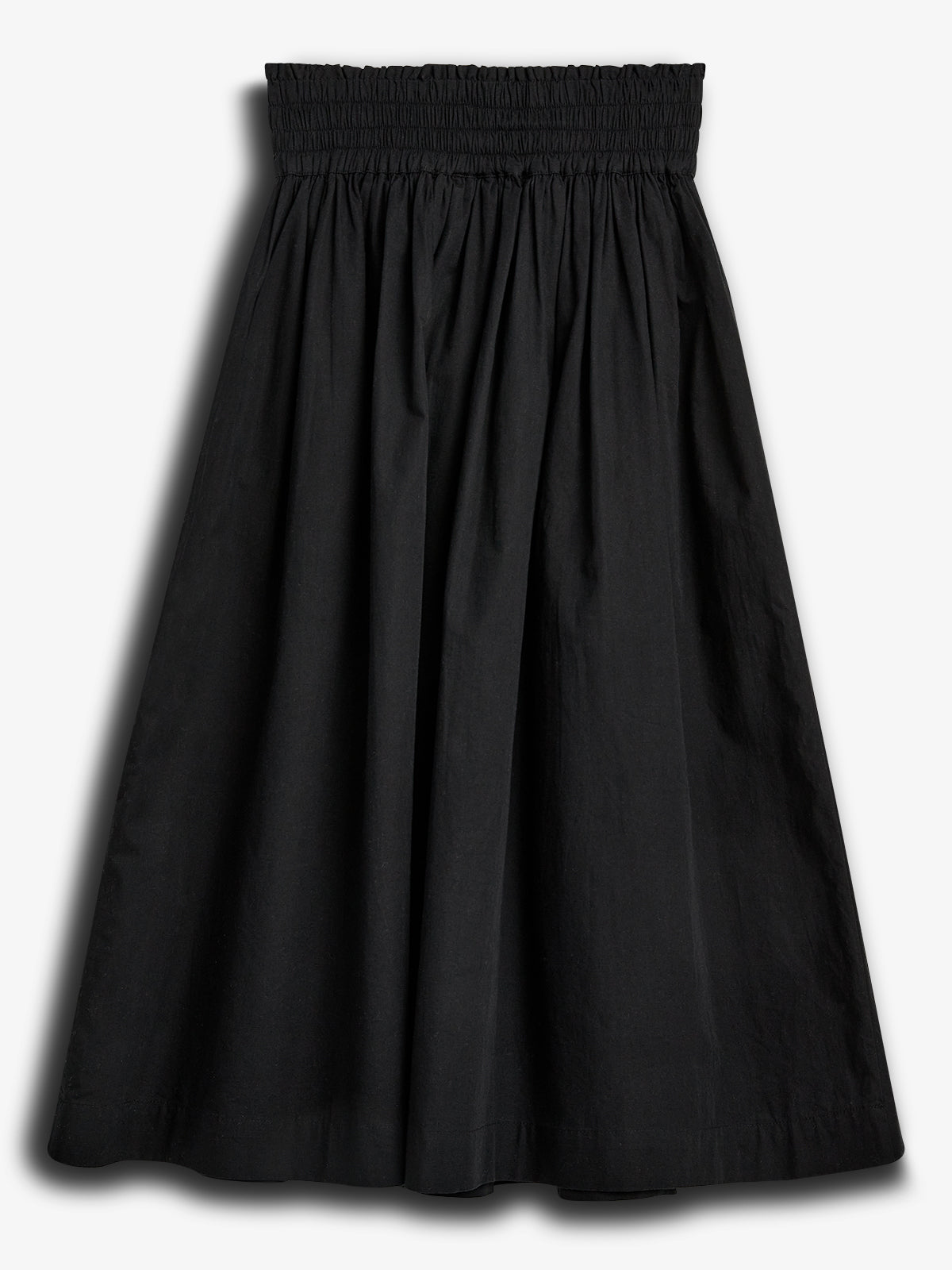 A black, knee-length skirt with an elastic smocked waistband, hangs against a plain white background, showcasing its gathered fabric and simple design.