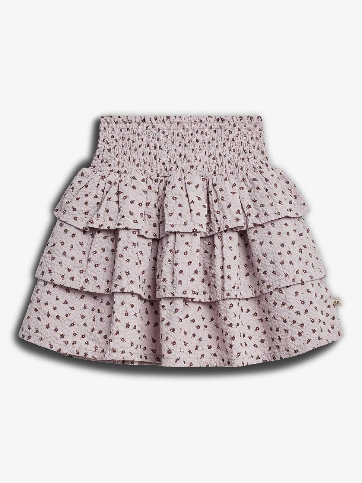 A tiered, ruffled skirt with a small floral pattern, featuring a shirred waistband. It is displayed against a plain, white background.