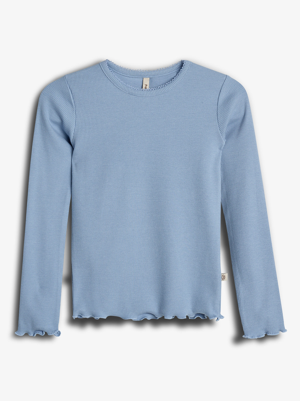 Lyseblå, langærmet ribbet bluse hænger mod en hvid baggrund. Blusen har små bølgede kanter ved ærmerne og nederst. En simpel og elegant udformning uden udsmykning.