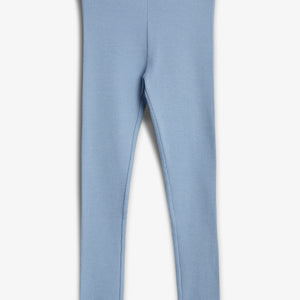 Blå leggings lavet af ribbet stof ligger fladt mod en hvid baggrund. Bukserne har en elastisk talje og bølgekant forneden.
