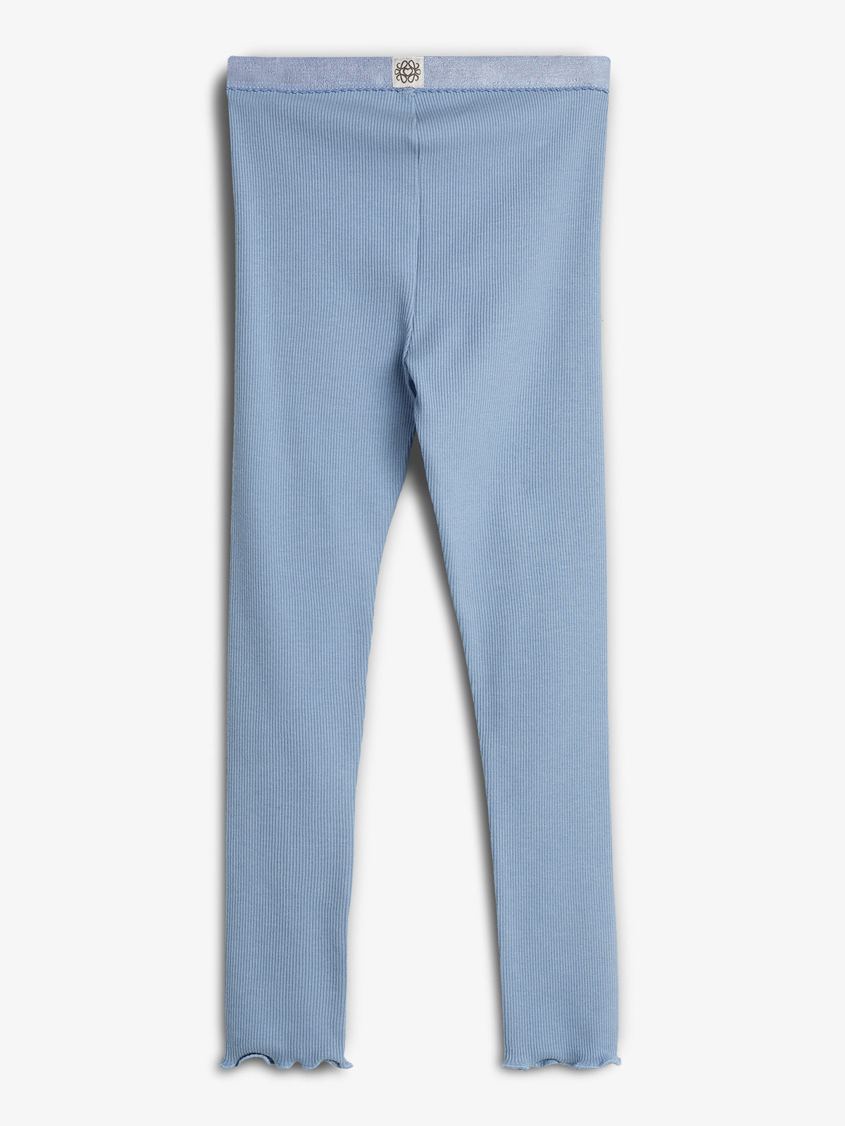Blå leggings med ribbet tekstur hænger uden bevægelse mod en hvid baggrund. En lille etiket med et blomsterdesign er synlig på linningen.
