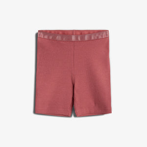 Røde shorts ligger fladt mod en hvid baggrund. Stoffet ser ribbet ud, og elastikken i taljen er tydelig. Ingen yderligere elementer i billedet.