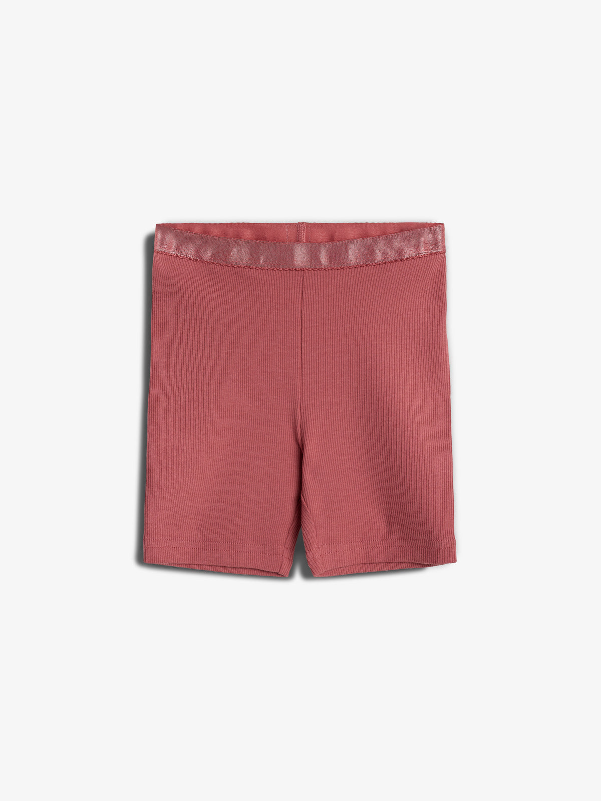 Røde shorts ligger fladt mod en hvid baggrund. Stoffet ser ribbet ud, og elastikken i taljen er tydelig. Ingen yderligere elementer i billedet.