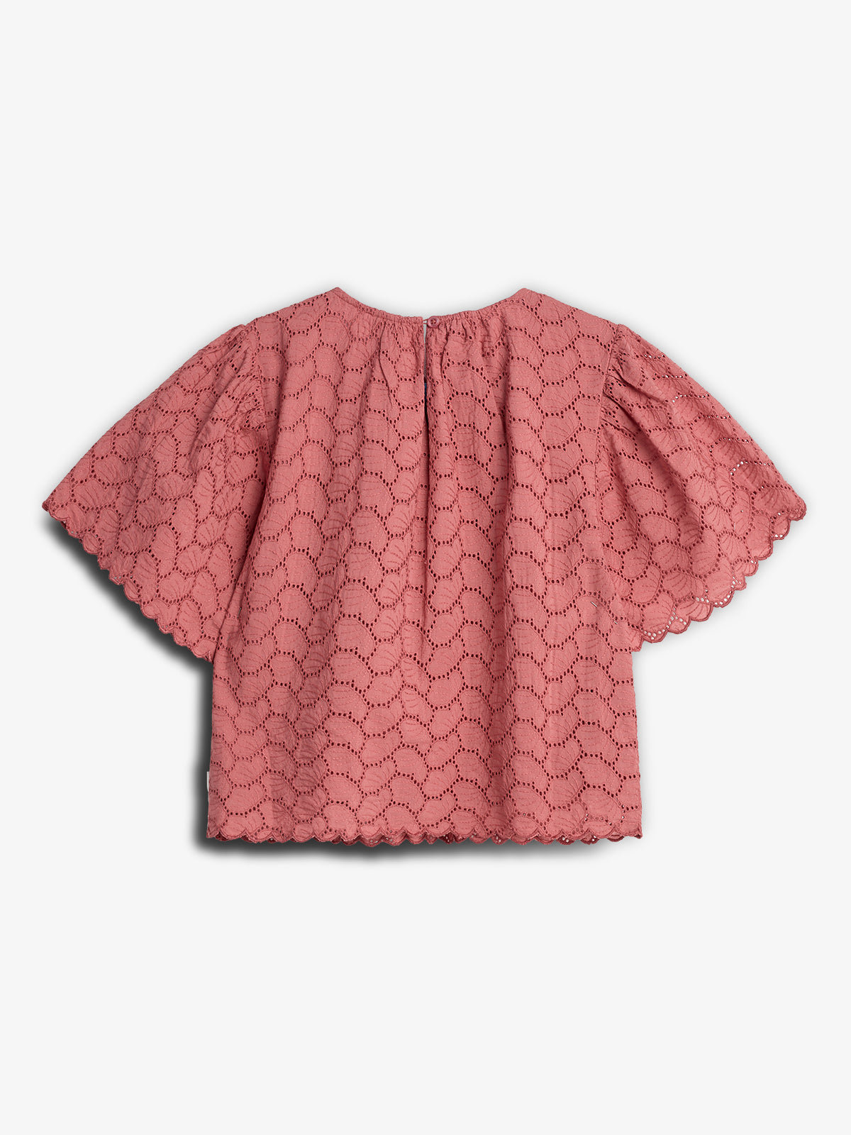 A pink lace blouse features scalloped edges and intricate embroidery, lying flat against a plain white background. The blouse displays short, loose sleeves and a round neckline.