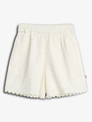 White, scalloped-edge shorts feature a delicate eyelet pattern. They are laid flat against a plain white background, emphasizing the intricate design and texture.