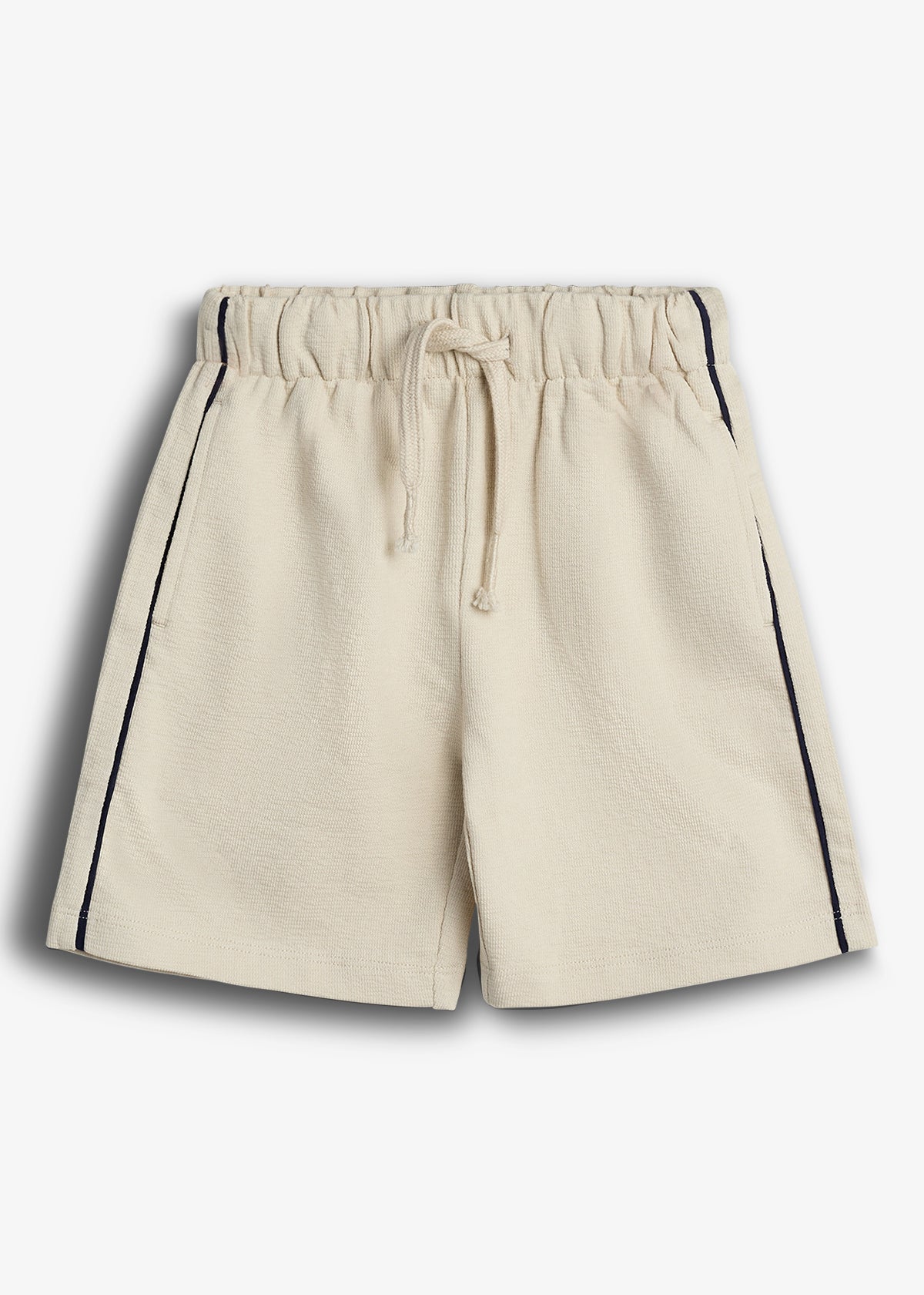 Beige shorts with a drawstring waistband, featuring navy piping along the sides. They are laid flat against a plain white background, highlighting the casual and comfortable design.