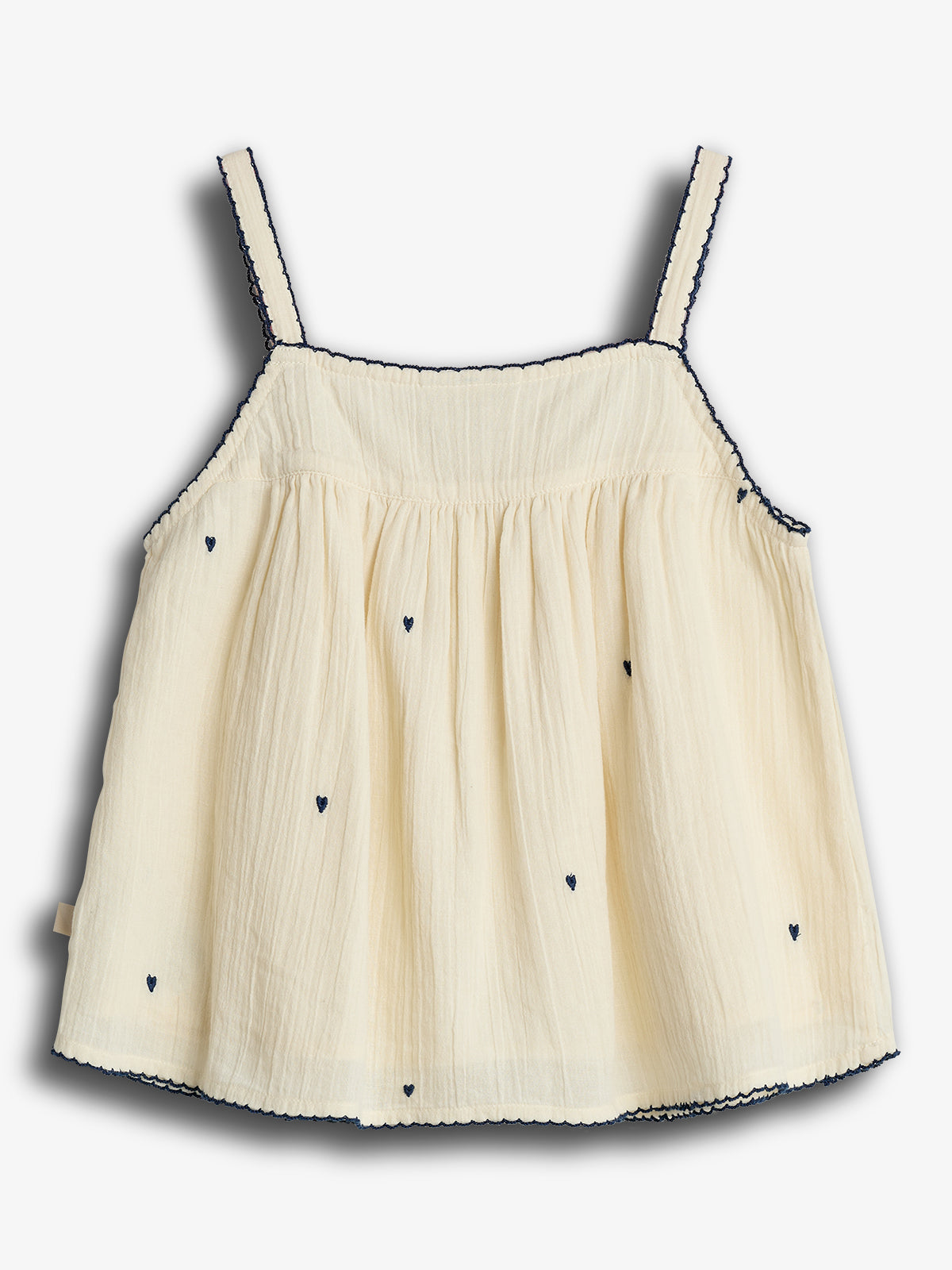 A sleeveless, cream-colored top with thin straps, featuring small embroidered navy hearts and scalloped edges. It is displayed against a plain white background.