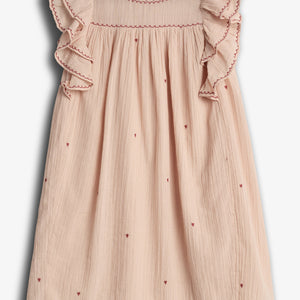 A light pink dress features red embroidered hearts and ruffled sleeves, with intricate stitching along the neckline and sleeves. The garment is displayed on a plain, light background.