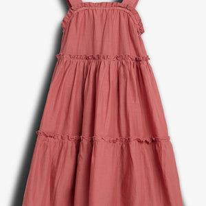 A pink, sleeveless, tiered dress hangs against a plain white background, displaying ruffled seams and broad shoulder straps.