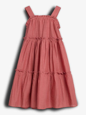 A pink, sleeveless, tiered dress hangs against a plain white background, displaying ruffled seams and broad shoulder straps.