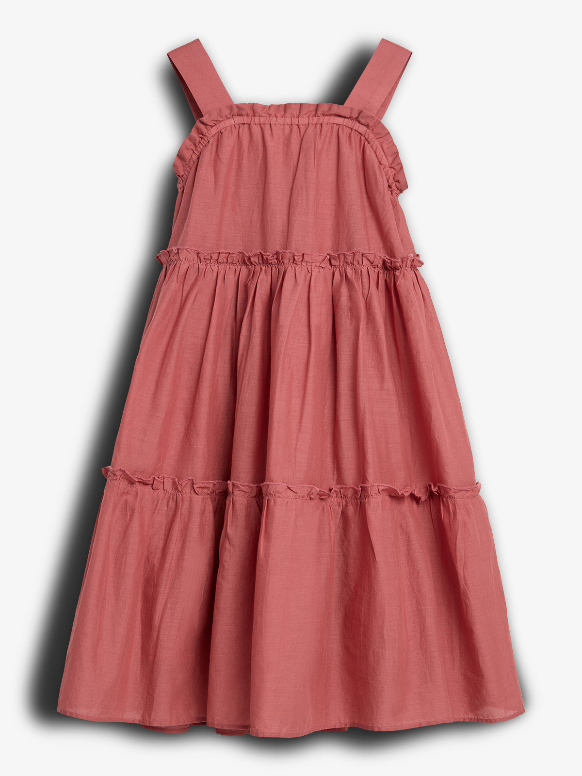 A pink, sleeveless, tiered dress hangs against a plain white background, displaying ruffled seams and broad shoulder straps.