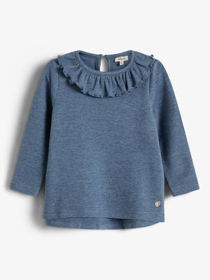 Langærmet blå bluse med rynket krave og en lille åbning bagtil ved nakken. Konteksten er en enkel, neutral baggrund. Text: "petit love".