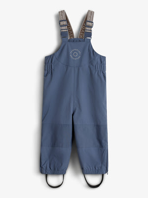 Blå selebukser med elastiske stropper, justerbare spænder, og tekst "ROMPDE LUX ADVENTURE" på forsiden, designet til udendørs leg. Baggrunden er en ensfarvet, lys overflade.