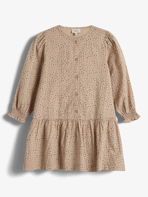 A beige, long-sleeved dress with black polka dots and front buttons rests on a plain white background. The dress features a gathered skirt and elasticized cuffs. Tag reads: "Prénatal".