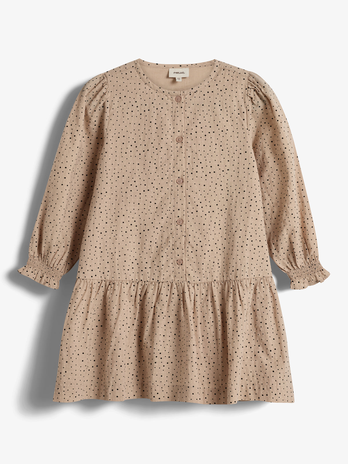 A beige, long-sleeved dress with black polka dots and front buttons rests on a plain white background. The dress features a gathered skirt and elasticized cuffs. Tag reads: "Prénatal".