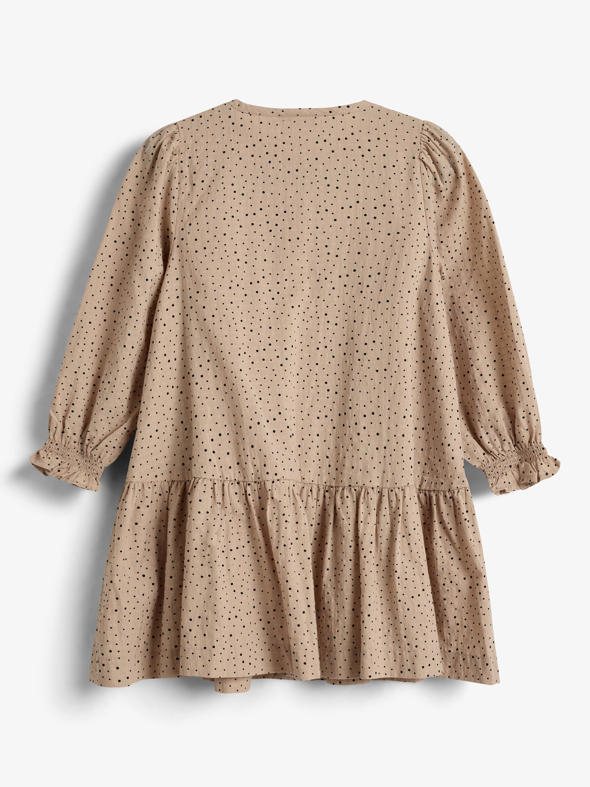 A beige dress with black polka dots hangs against a white background. It features long sleeves with ruffled cuffs and a gathered, ruffled skirt section, creating a casual, elegant style.