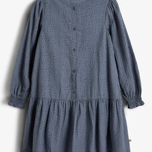 A blue, long-sleeve, button-up dress with a dotted pattern hangs against a white background. It features gathered cuffs and a ruffled hem. Text on the label reads "PRIMARK" and "10."