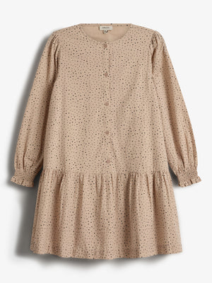 En beige kjole med sorte prikker hænger stille. Knappet foran med lange ærmer og rynket nederdel. Baggrunden er neutral og lys. Tekst: "Minimango."