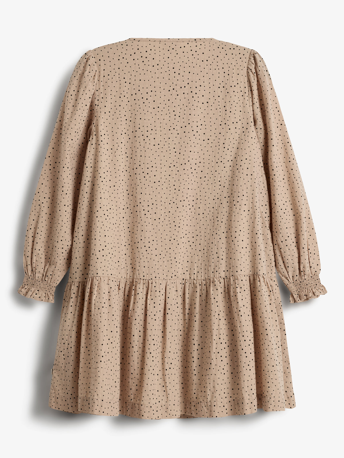 Beige kjole hænger stille; prikmønstret stof med lange ærmer og rynker i ribben; neutral baggrund.