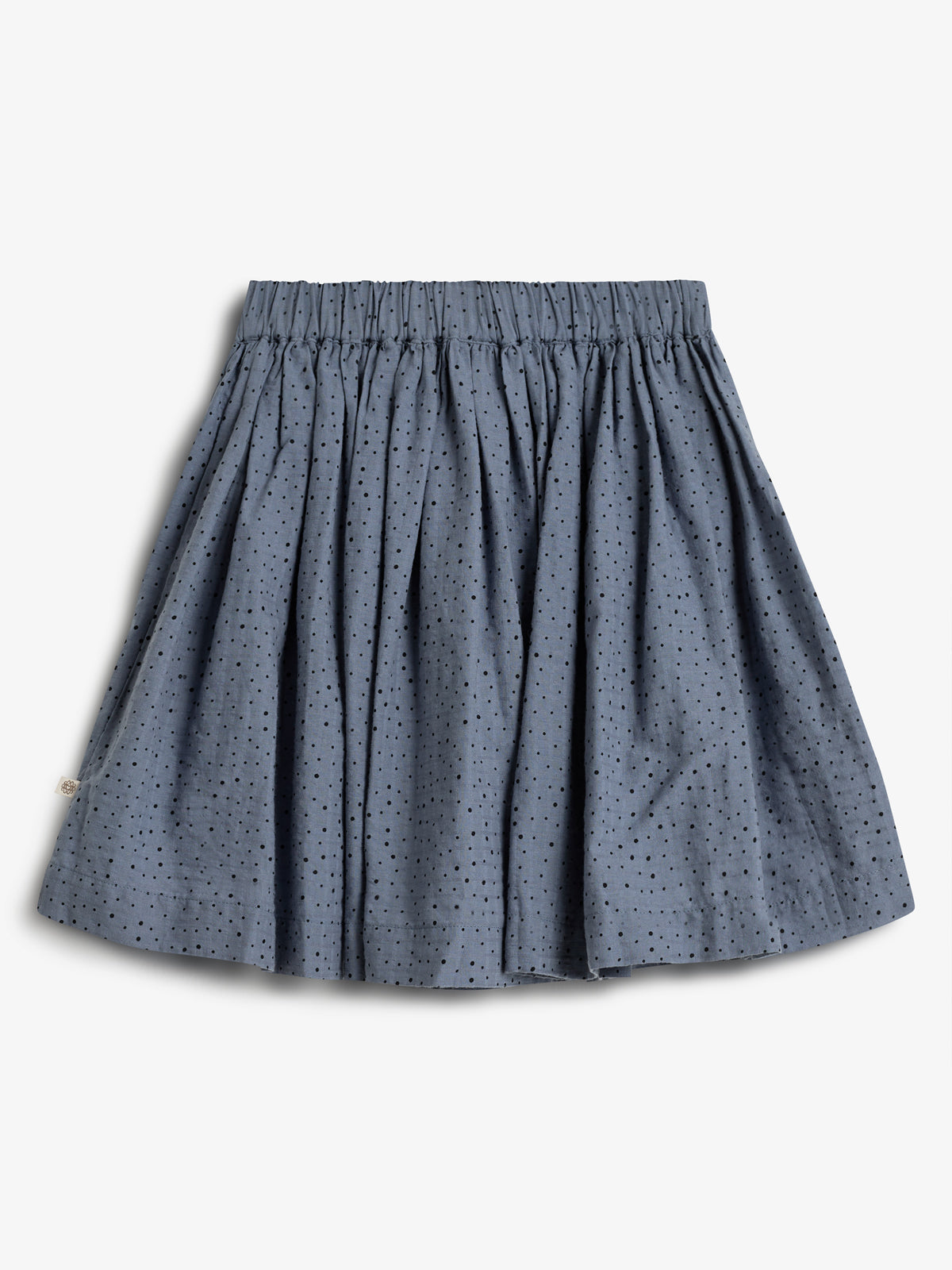 A blue, pleated skirt with small black polka dots is laid flat on a white background. The skirt appears to have an elastic waistband.